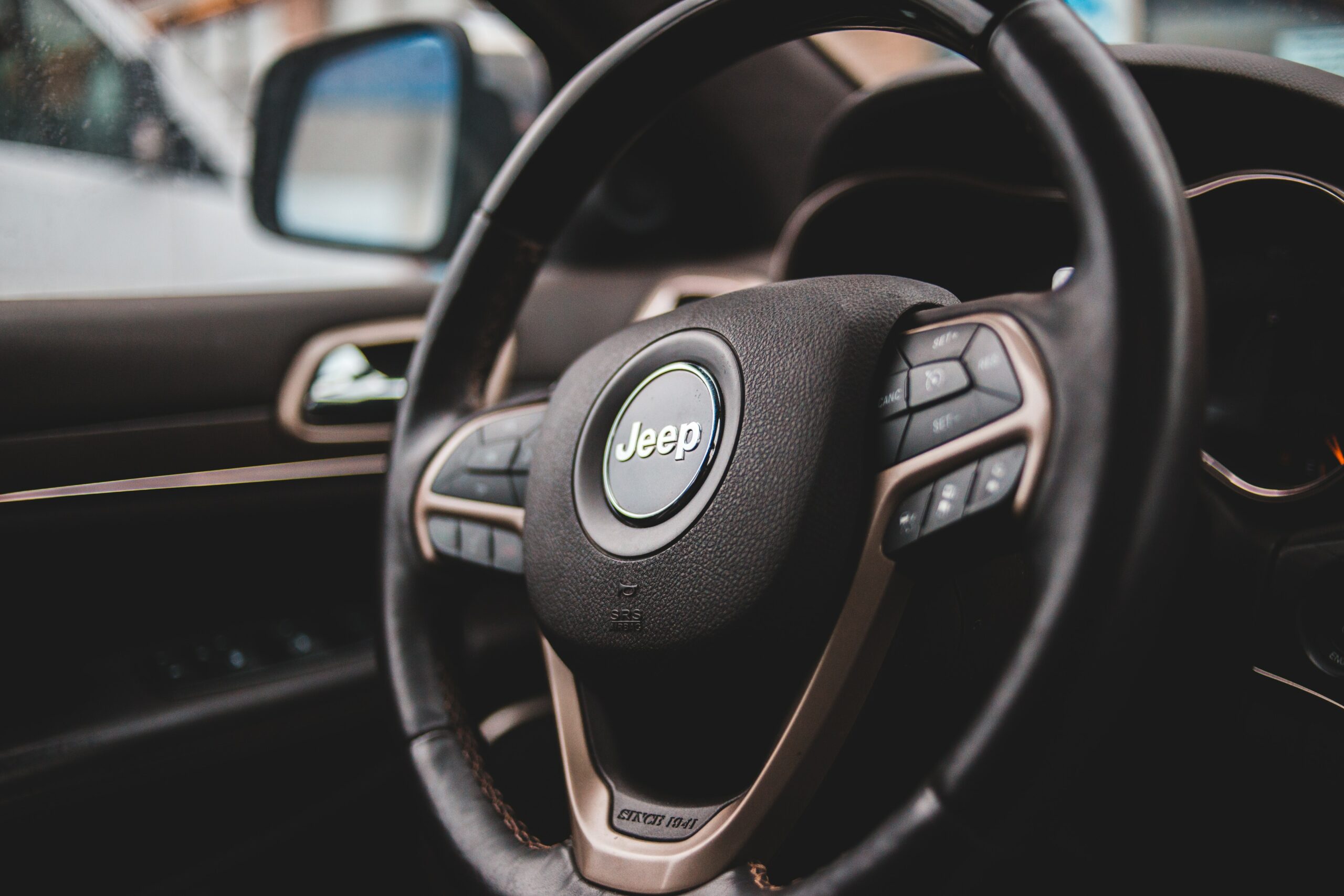Steering wheel with the Jeep logo inside a Jeep cabin