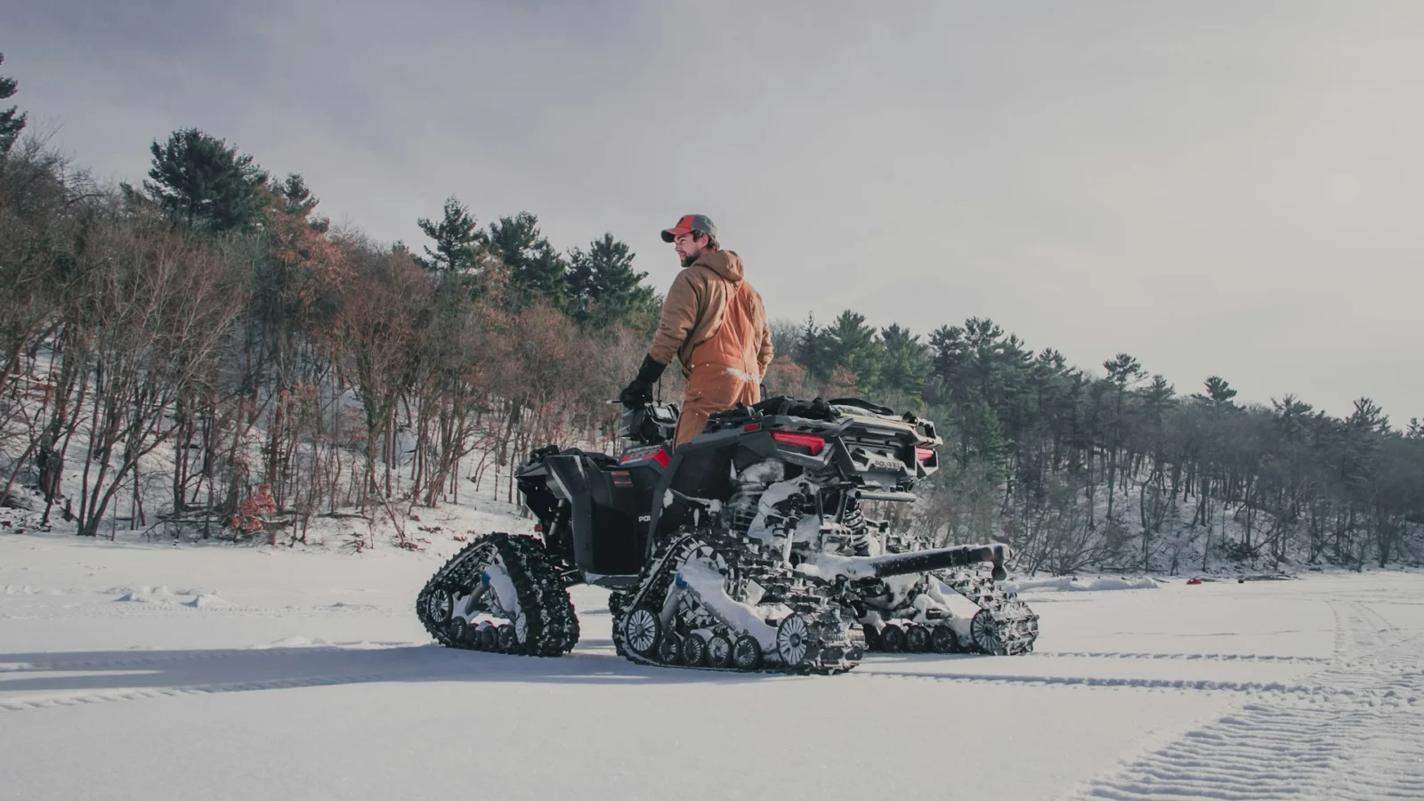 Utility ATV fitted with snow tracks on a frozen field