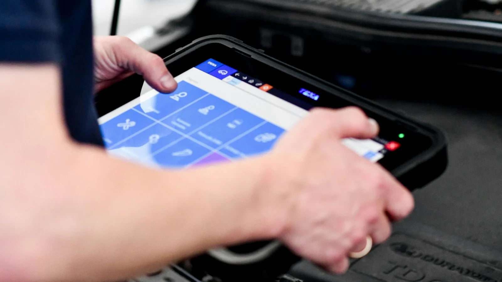 Hands using a diagnostic scan tool tablet