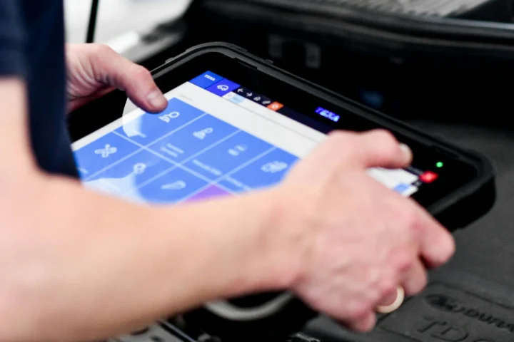 Hands using a diagnostic scan tool tablet