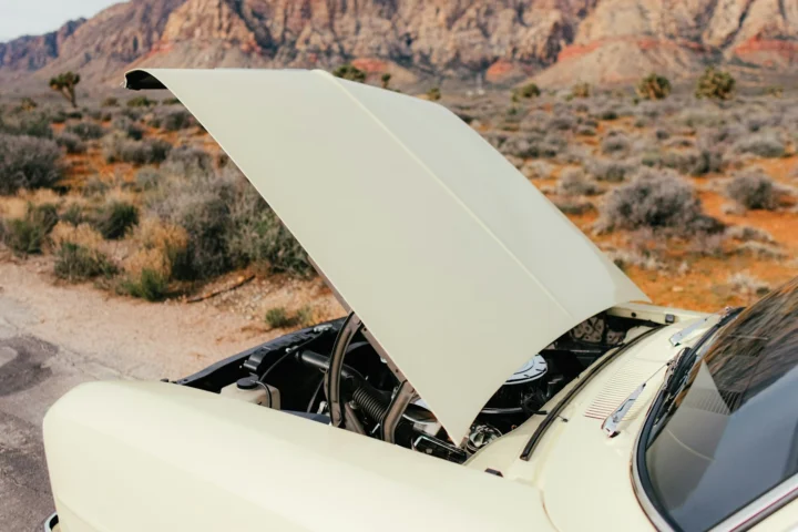 Car with its hood open on a desert road