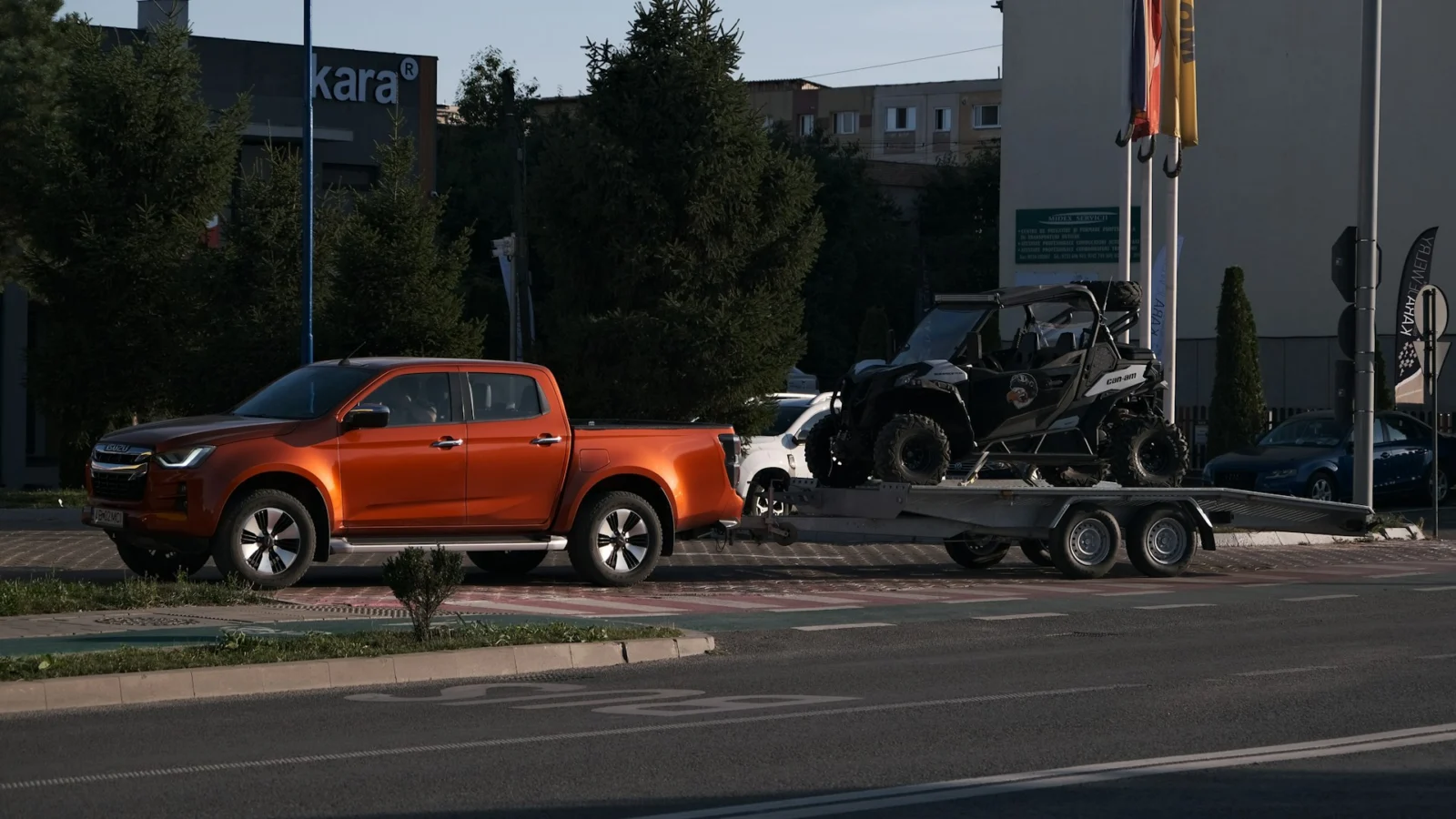 Pickup truck towing a side-by-side on a flatbed trailer