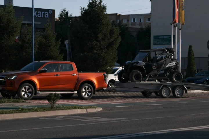 Pickup truck towing a side-by-side on a flatbed trailer