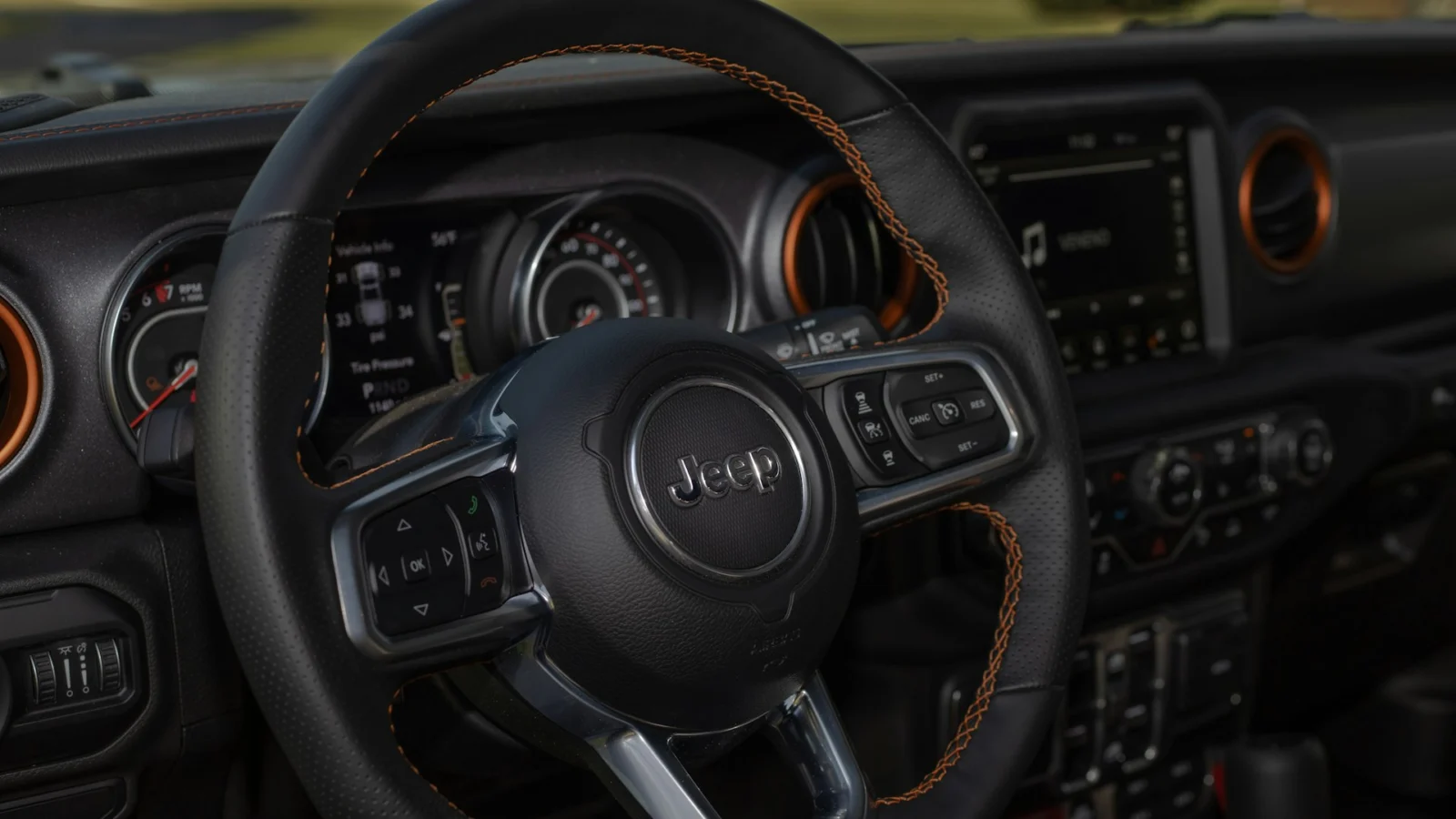 Steering wheel with the Jeep logo and the instrument cluster of a Jeep Wrangler JL
