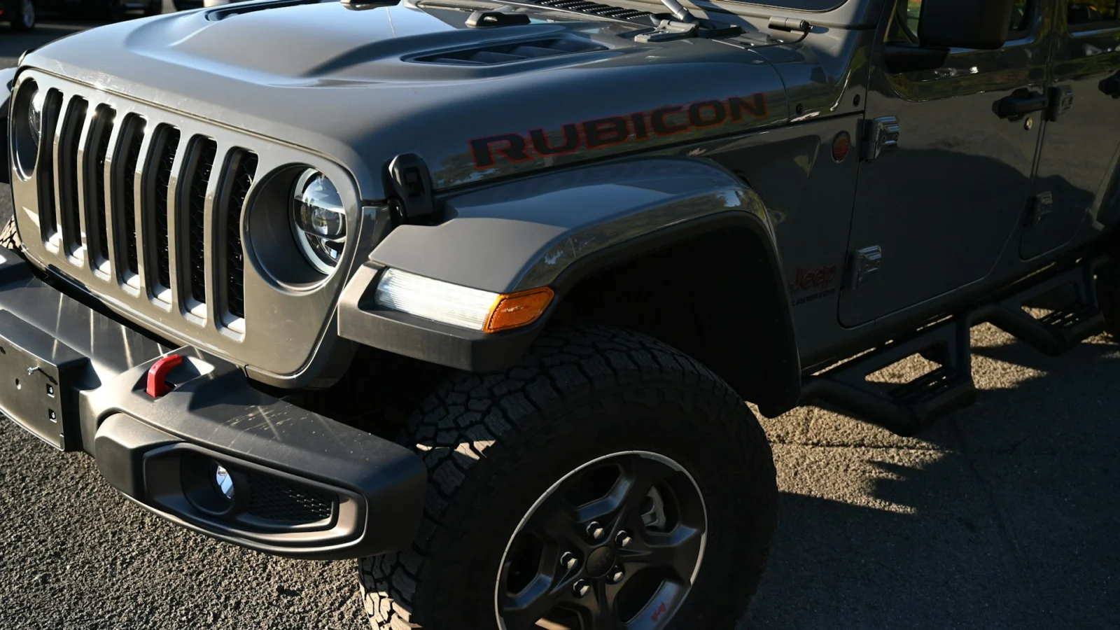 Front wheel and off-road tire of a gray Jeep Gladiator Rubicon